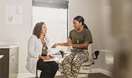 Doctor speaking with patient in military fatigues