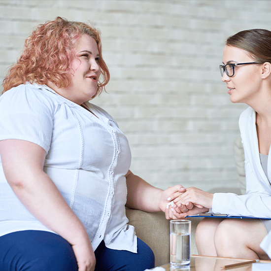 Physician holding hand and discussing with patient with obesity