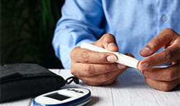 Man testing his blood with glucose test strip