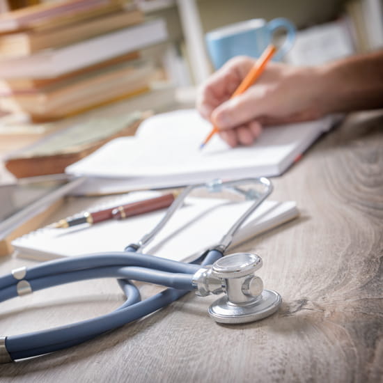 Provider taking notes and stethoscope