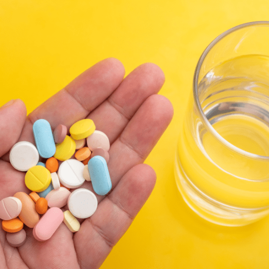 Assortment of tables in a hand next to a glass of water
