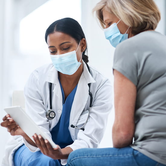 Doctor reviewing notes on tablet with patient