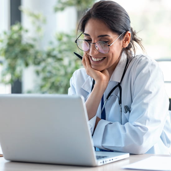 South Asian Woman watching laptop computer