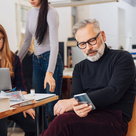 Man looking at phone in office