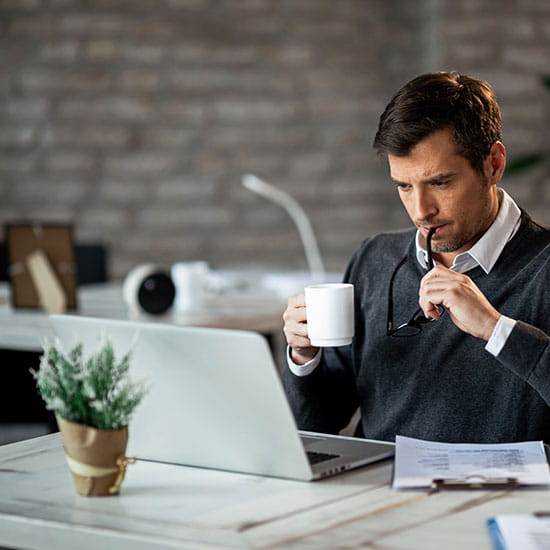 man reading newsletter at computer