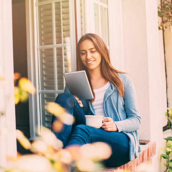Woman reading tablet with coffee