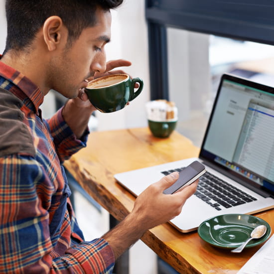 Man on computer drinking coffee
