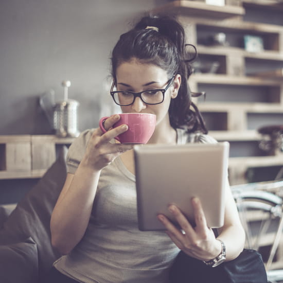 Woman with coffee and tablet computer