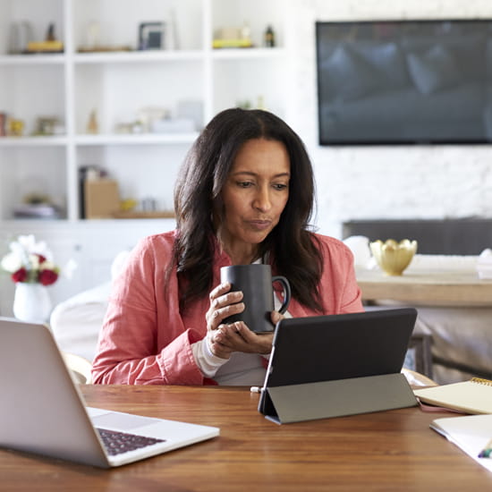Woman with coffee looking at tablet