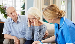 Doctor talking to elderly patient with a caregiver present