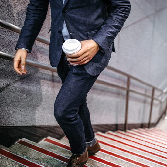 man walking up stairs with coffee 