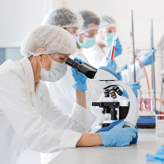 scientist looking through microscope