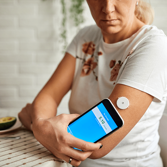 women using smartphone for glucose monitoring app