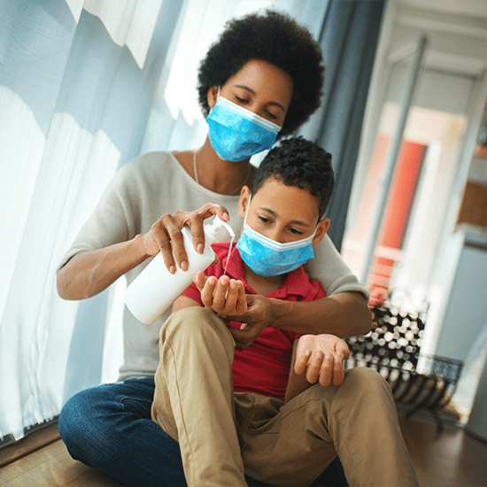 woman using hand sanitizer with child
