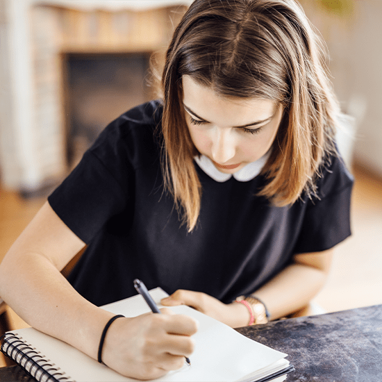 Girl in chair writing in journal