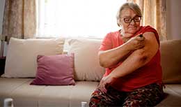 Senior female injecting insulin in arm 