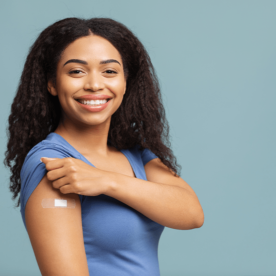 woman with bandaid on arm smiling