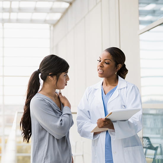 Doctor speaking with a patient in a hallway