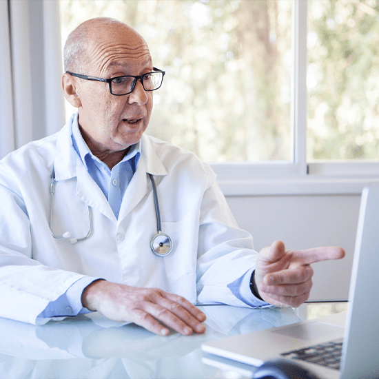 doctor speaking in front of laptop
