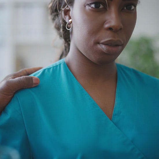 Male physician touching female colleague's shoulder