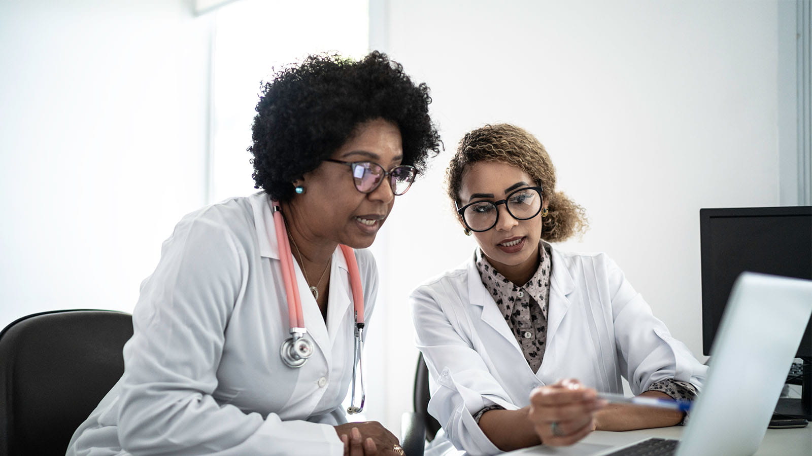 Two female doctors sitting in front of computer