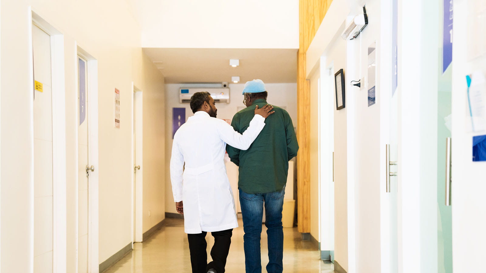 Doctor talking to patient walking down hall