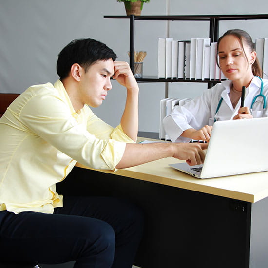 Patient consulting with doctor holding head
