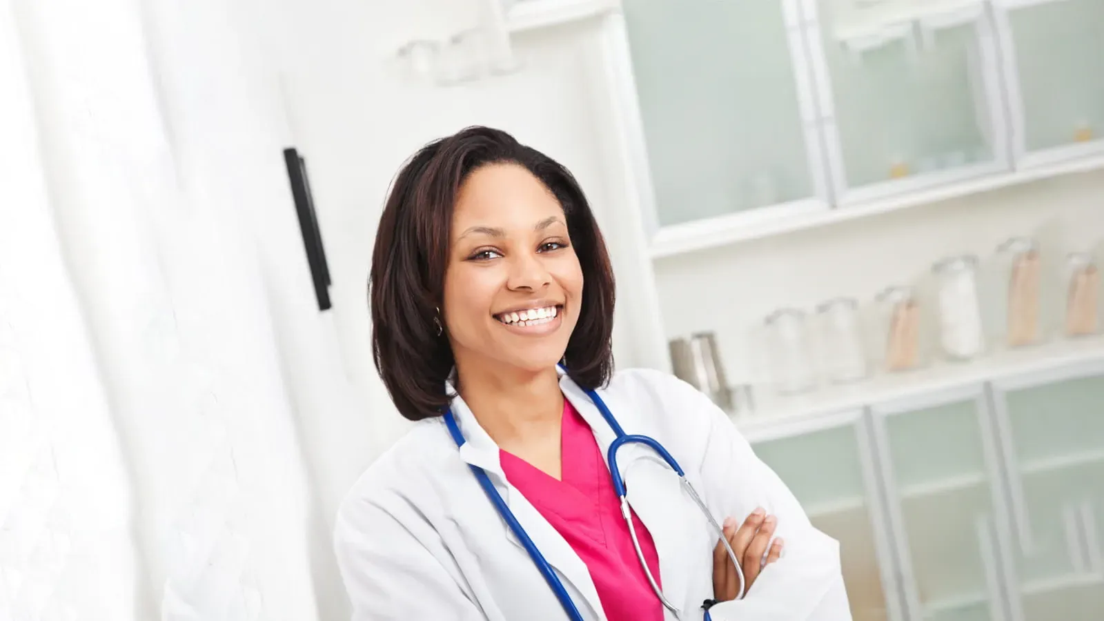 Female doctor wearing pink scrubs smiling