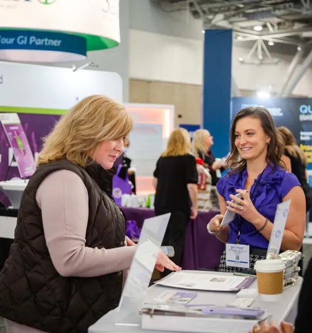 two ladies discussing products in exhibit hall