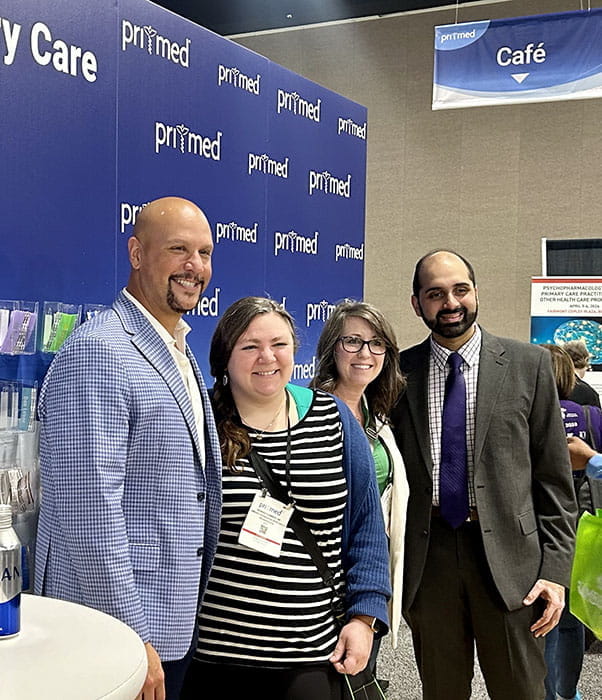 Doctor James Simmons and Dr. Anu Hazra meeting clinicians in the Pri-Med Booth at a conference.