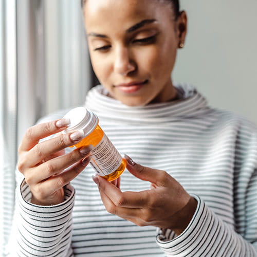 Woman examining a medicine bottle