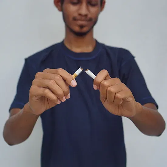 Man breaking a cigarette in half