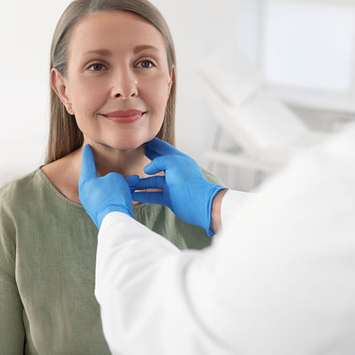 Endocrinologist examining thyroid gland of patient