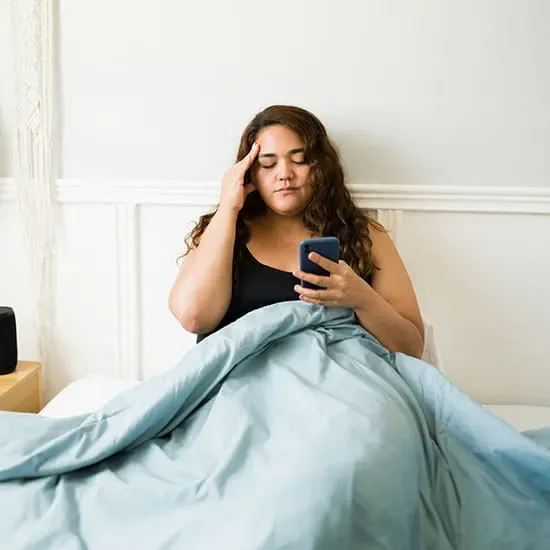 woman in bed with smartphone