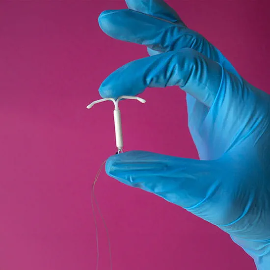gloved hand holding iud