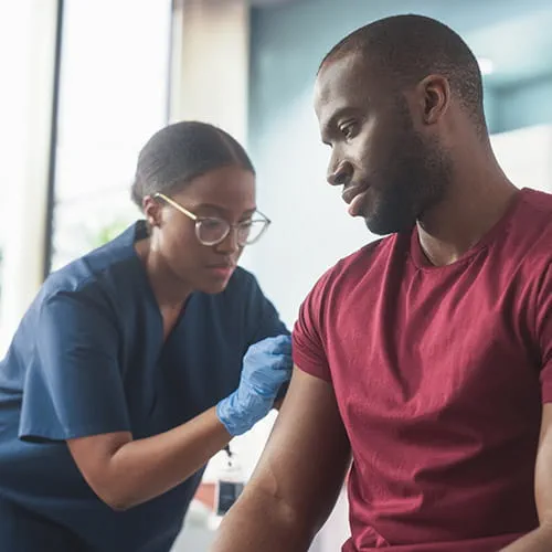 Man receiving a shot from a nurse