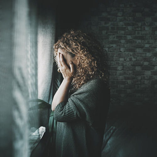 Sad woman looking outside window