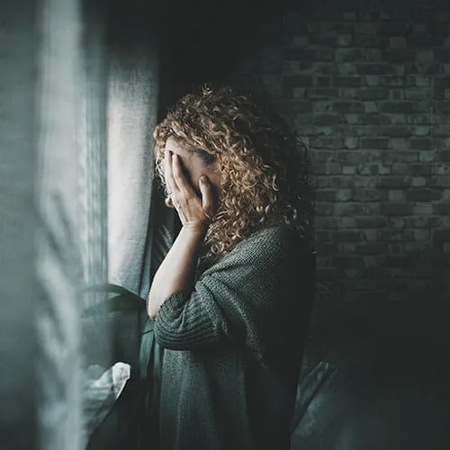 Sad woman looking outside window