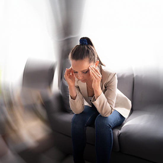Woman sitting on a couch with dizziness