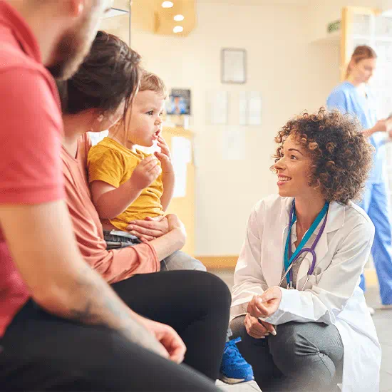 doctor kneeling next to family