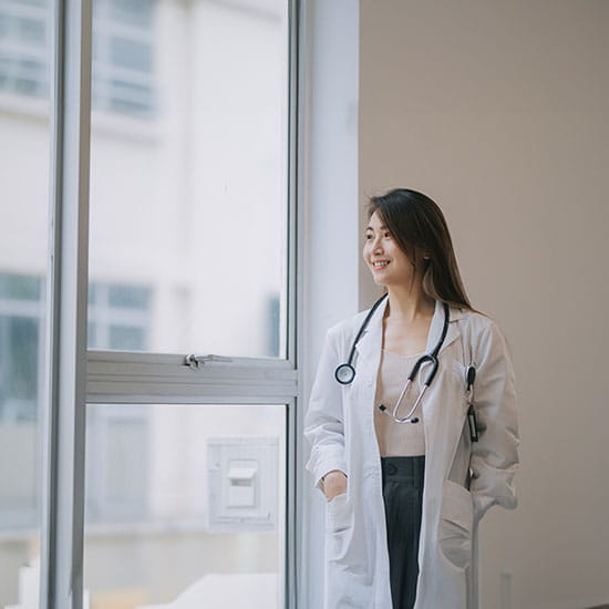 Female doctor standing in front of window