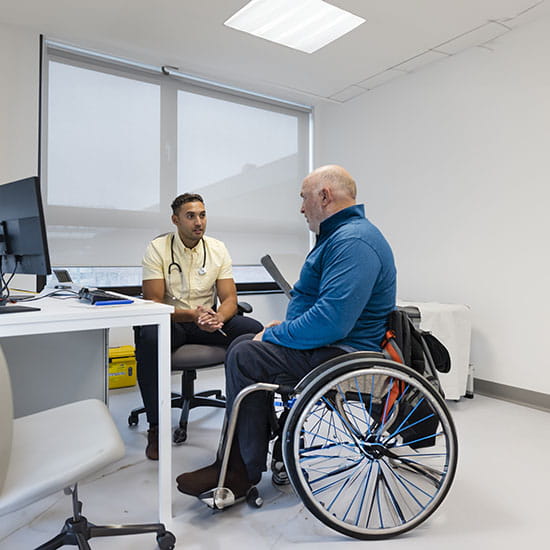 Doctor conversing with patient in a wheel chair