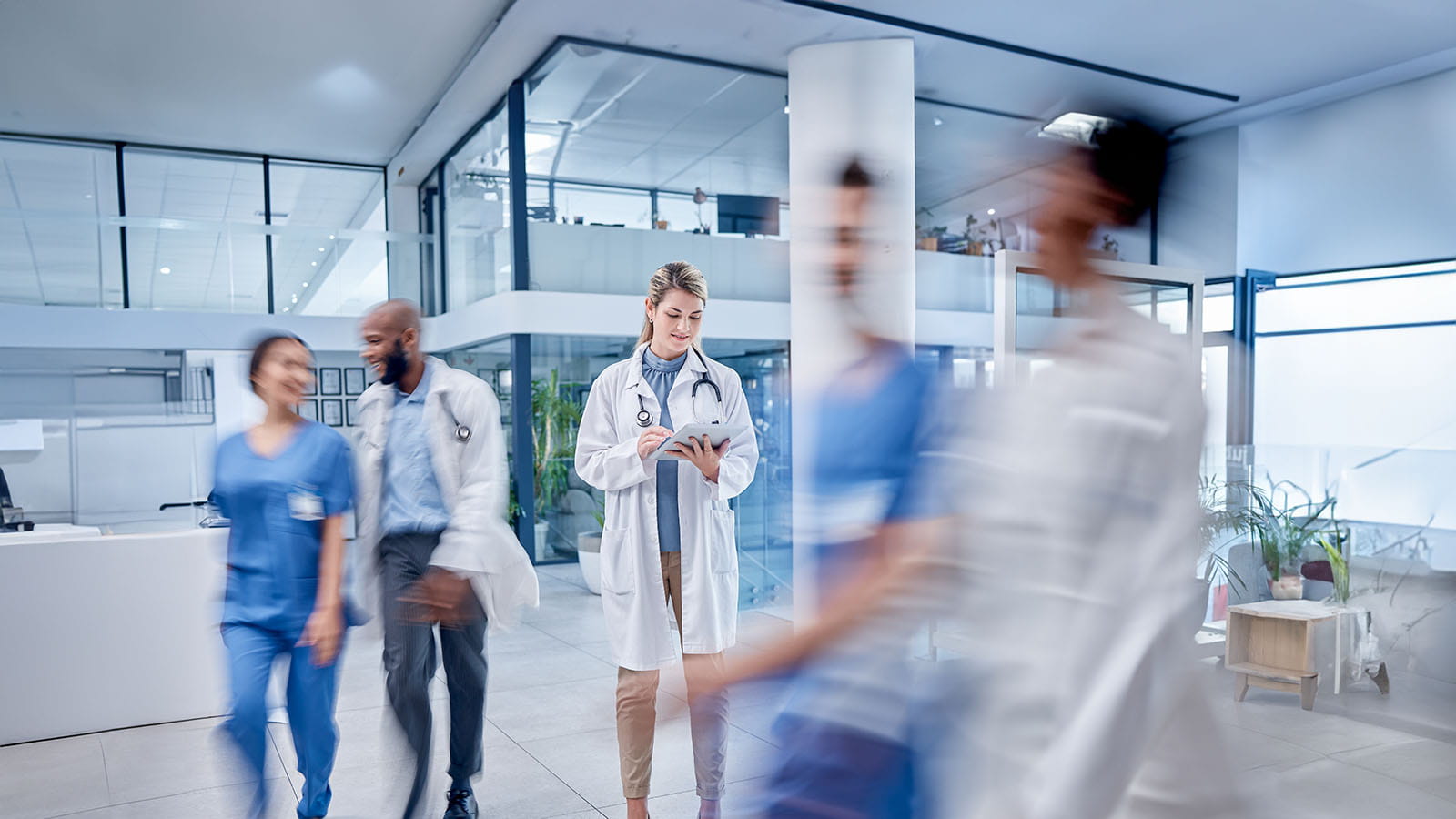 Woman with a tablet in a busy hospital