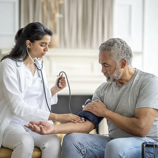 Doctor checking patient's blood pressure at home