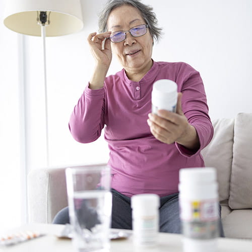 Lady looking at a bottle of pills