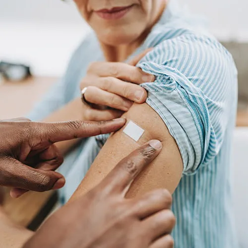 Person putting a band aid on a patient