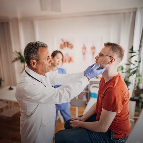 Doctor examining patient's thyroid glands