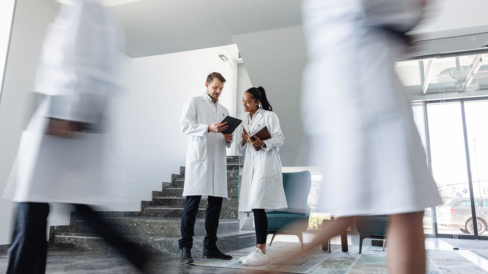 Doctors talking to each other while standing in a corridor