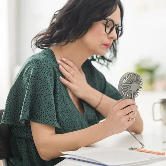 Woman fanning herself in an office