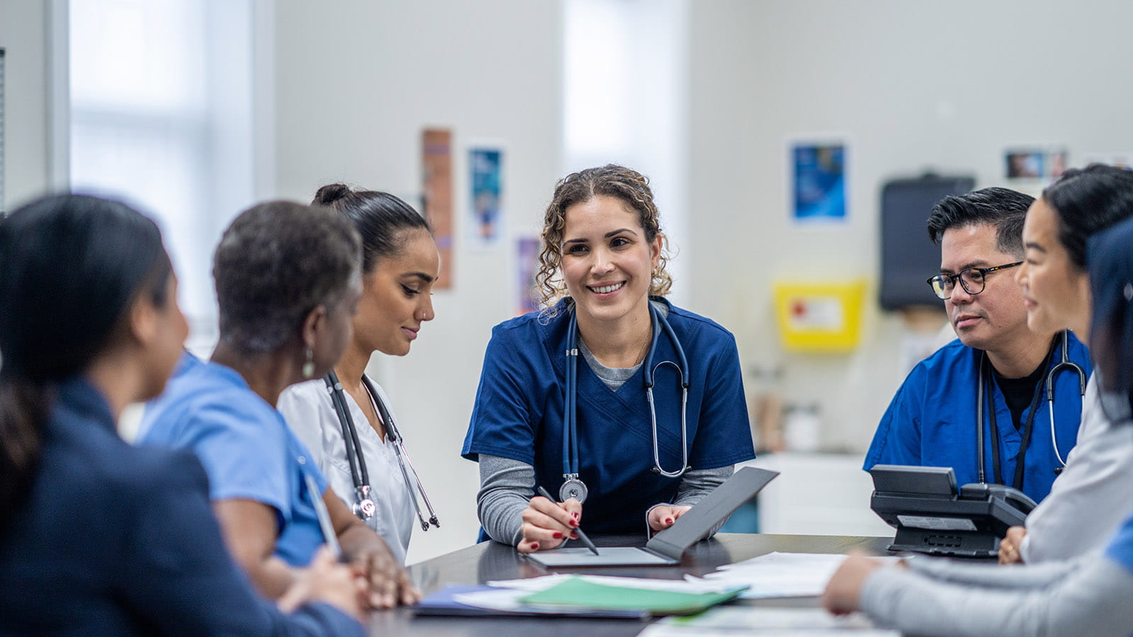 Medical workers conversing by a table